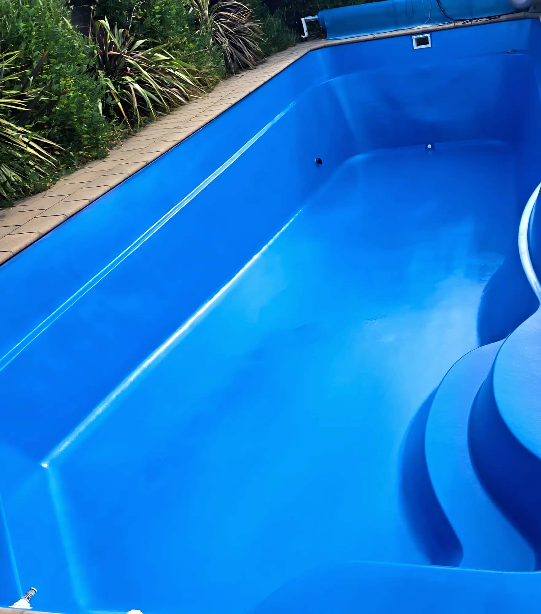 Glossy blue recoated fibreglass pool with sculpted entry steps
