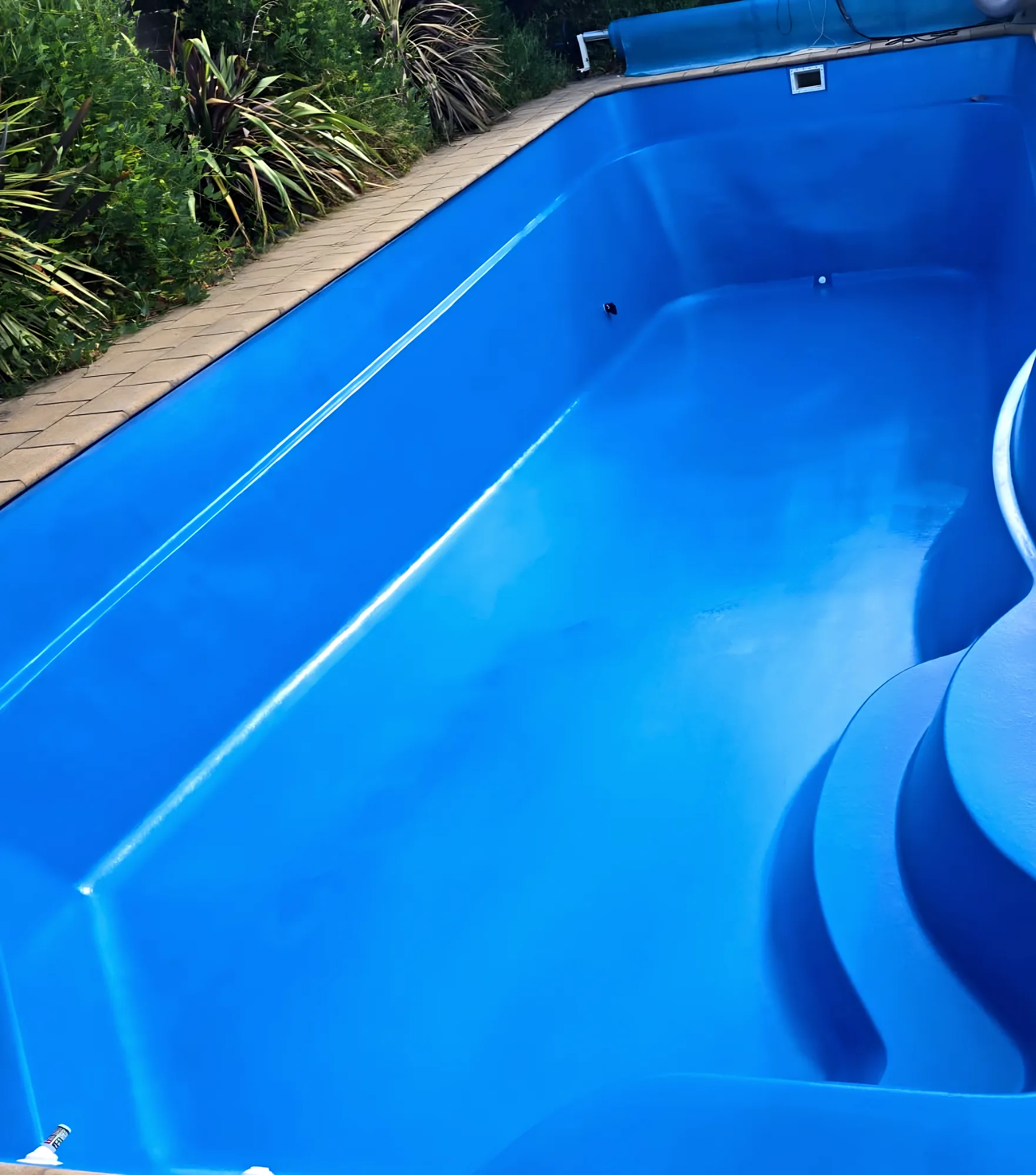 Glossy blue recoated fibreglass pool with sculpted entry steps
